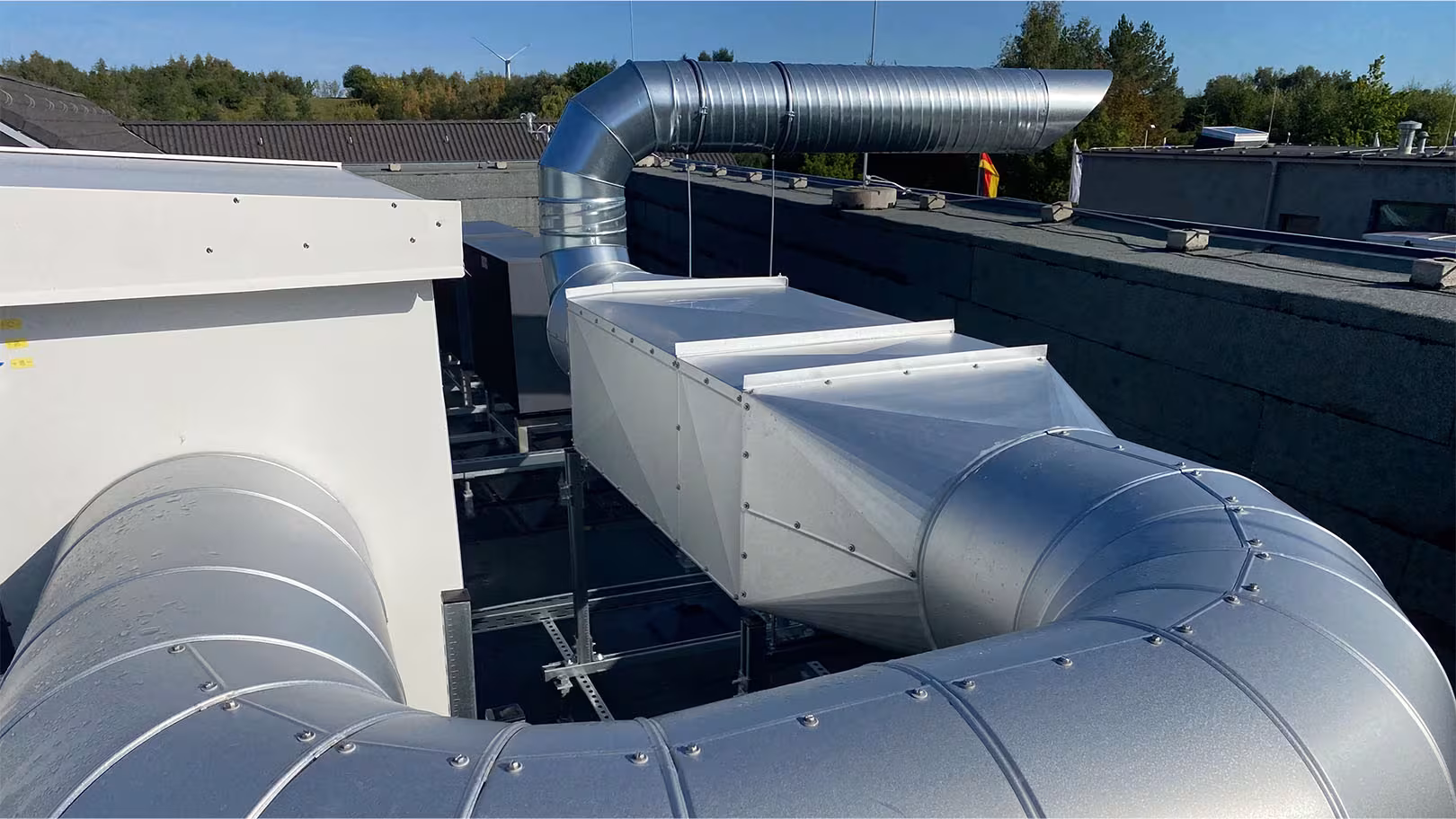 Isolierte Lüftungs- und Abluftkanäle mit Aluminium-Mantel auf dem Dach eines Verteilerzentrums
