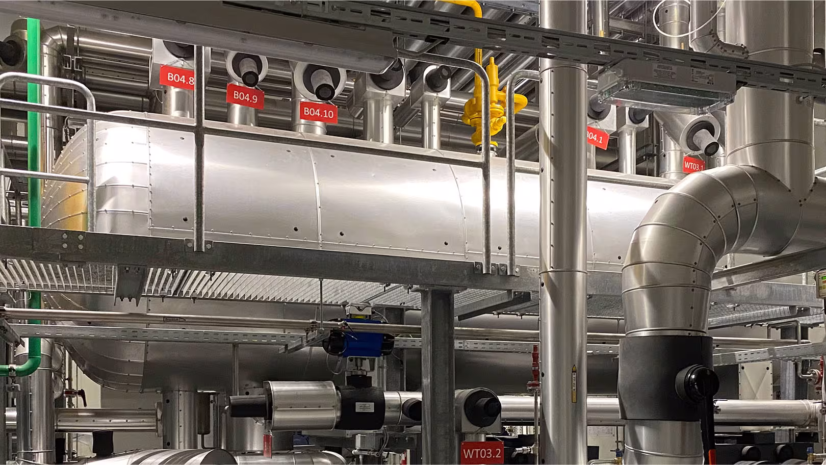 Komplett isolierter Maschinenraum mit beschrifteten Rohrleitungen B04 und Wärmetauschern WT03, Skid-Montage durch IVS
