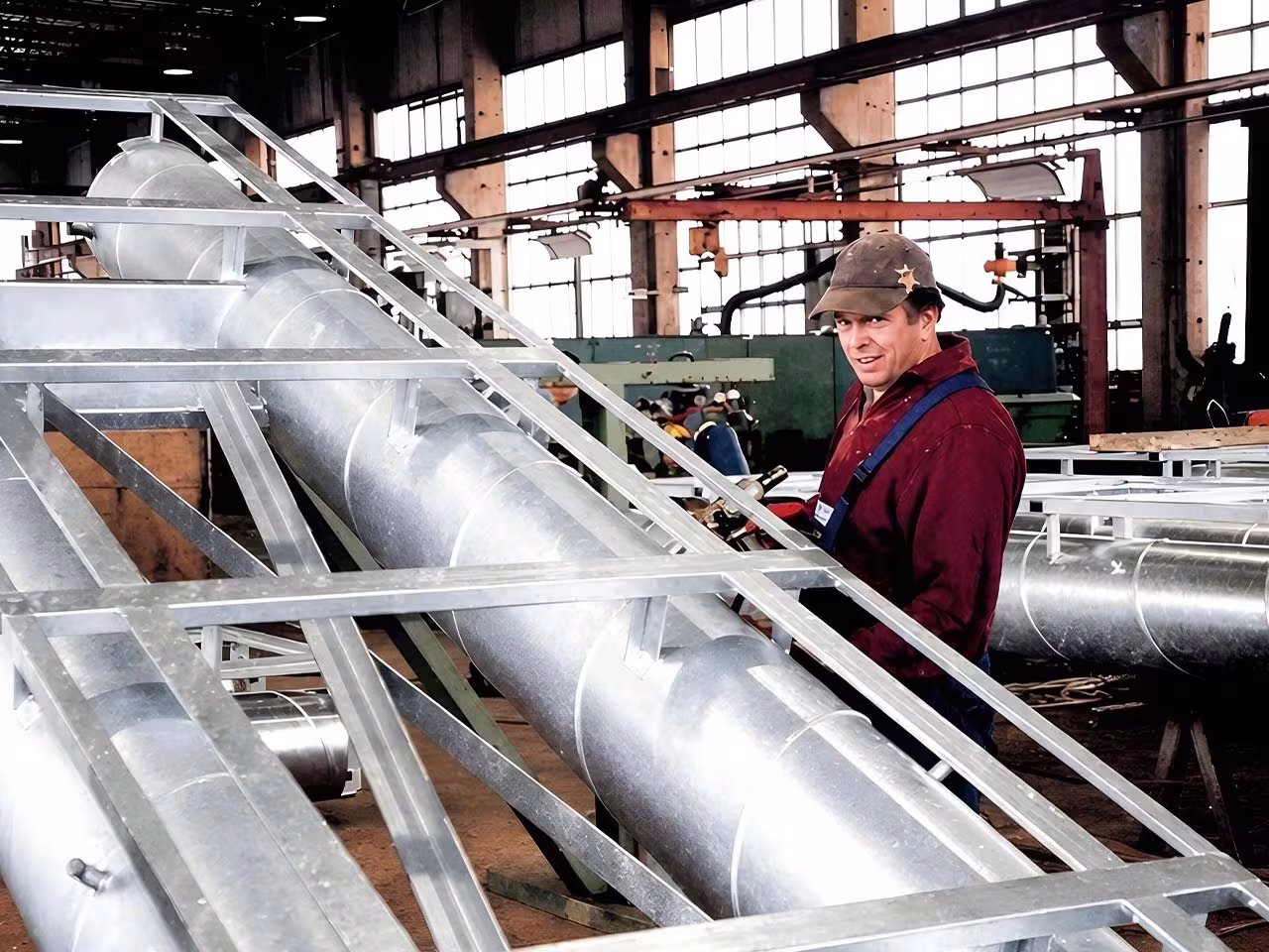 Eingeschäumte Rohrleitungs­komponenten aus PUR-Hartschaum im Stahlgerüst, Vorfertigung in der Hochdruck­schaum-Anlage der IVS-Werkstatt