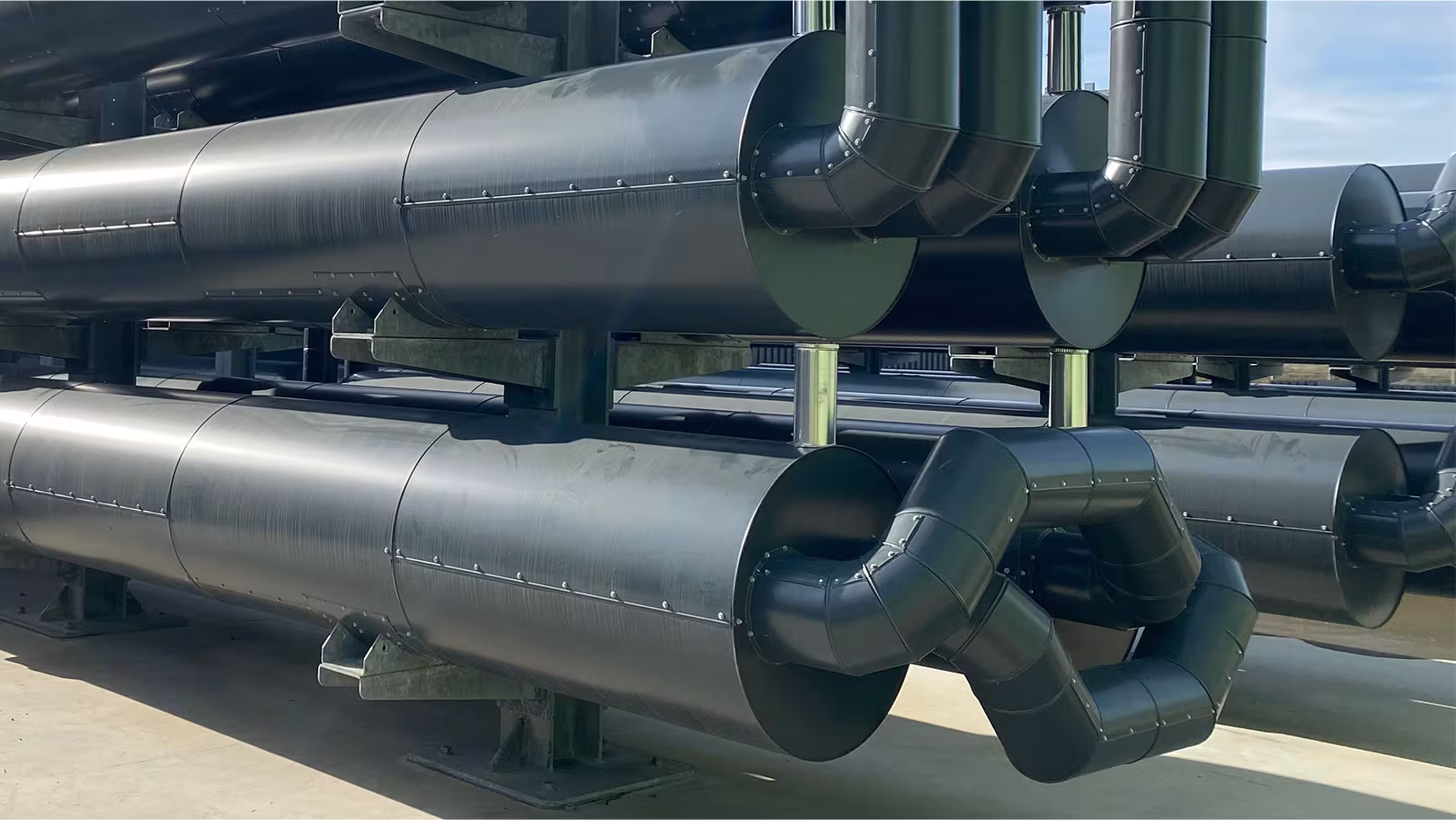 Gedämmte Gas- und Rohrleitungen mit schwarzem Blechmantel und Bogenisolierung