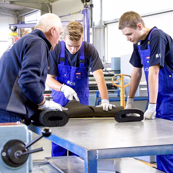 Three IVS employees showing a student the build-up of cold insulation during a taster day in the Malchin workshop