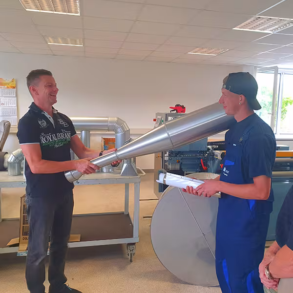 Reinhard und Michael Swienty überreichen Lucas Stegemann den Gesellenbrief zum WKSB-Isolierer in der IVS-Werkstatt