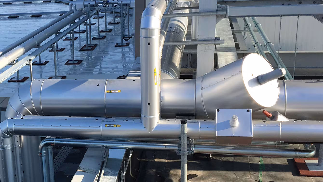 Technical insulation of industrial pipework with a stainless steel jacket on a plant roof area, carried out by IVS Isoliertechnik