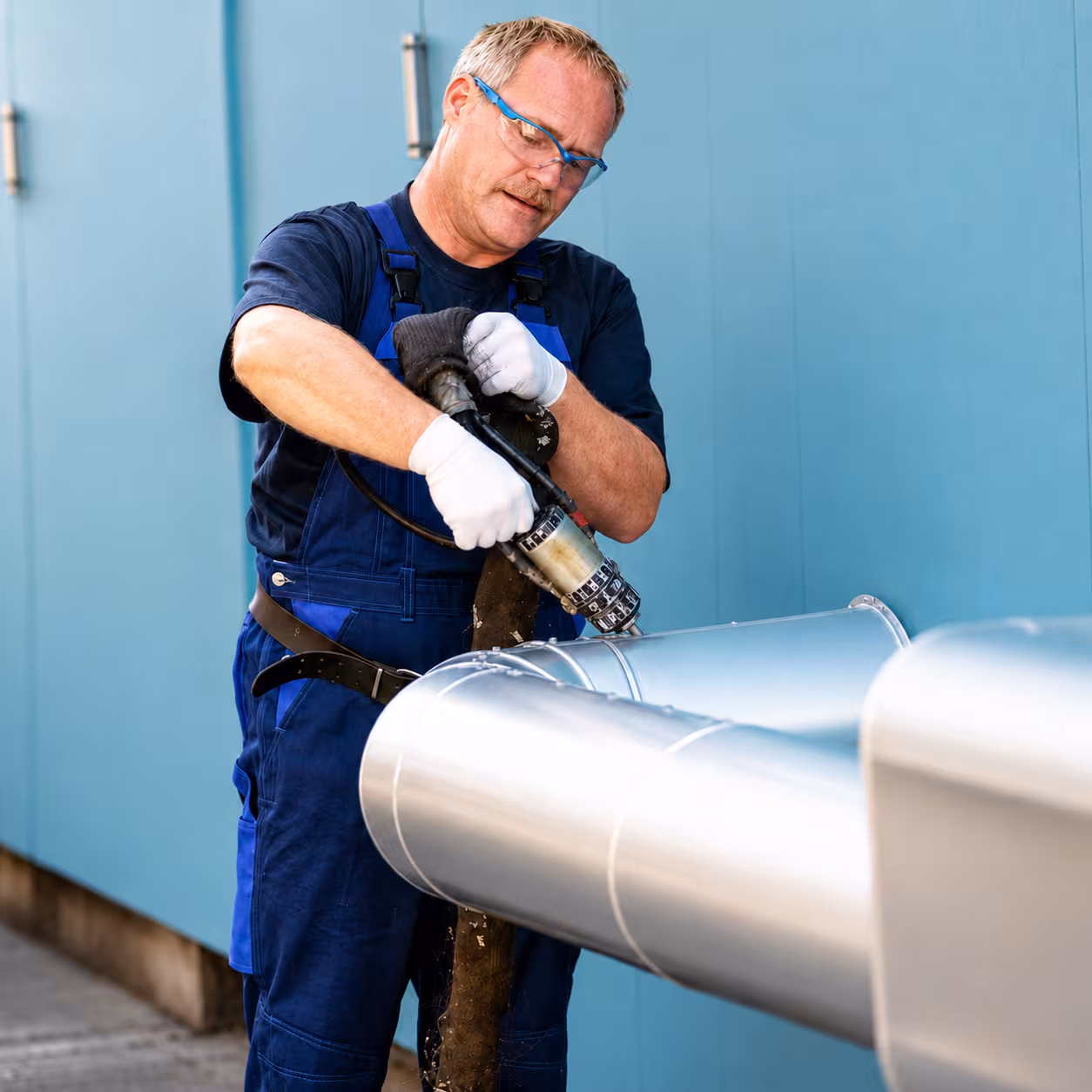 Mitarbeiter bei der PUR-Verschäumung an einer isolierten Rohrleitung für industrielle Kälteisolierung