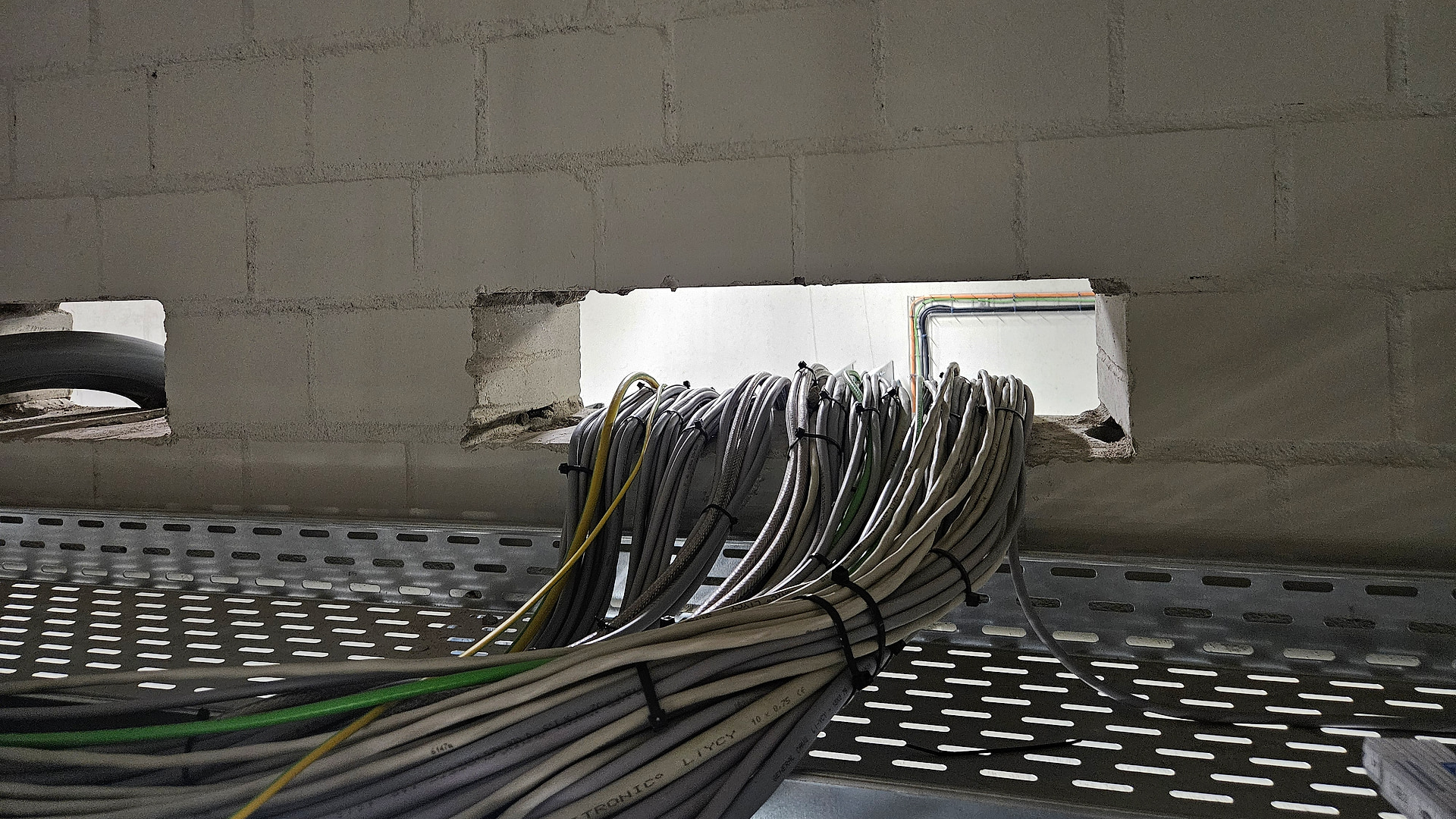Open cable penetration in fire wall 07 before the soft seal was installed at Sweet Tec